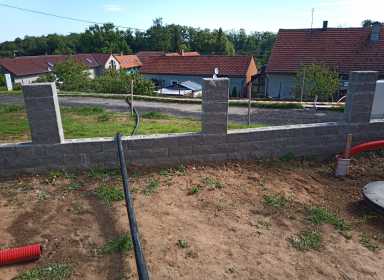 dole za domkama stojí výrobní zařízení BREMAT